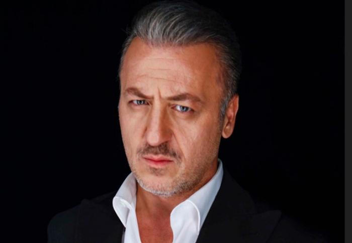 Barış Falay poartă o cămașă albă și un sacou negru