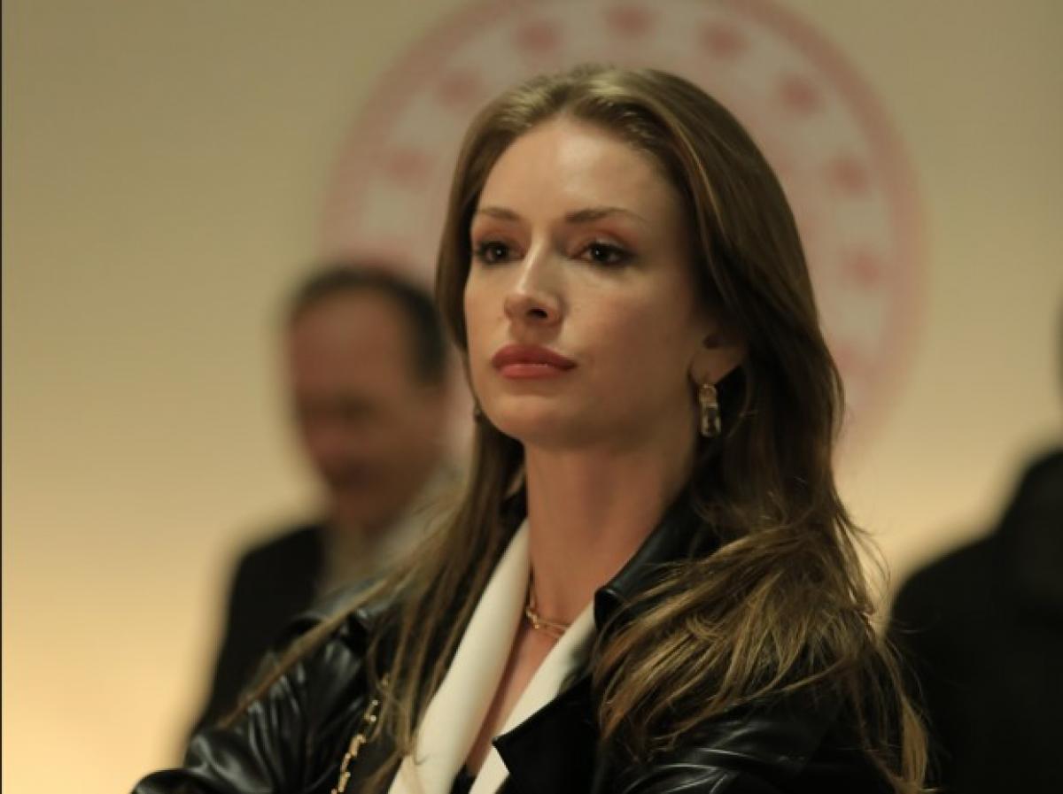 Yasemin Allen poartă părul desprins și își ține mâinile împreunate