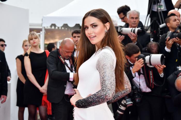 Fahriye Evcen Özçivit poartă o rochie albă cu mâneci lungi și are părul desprins