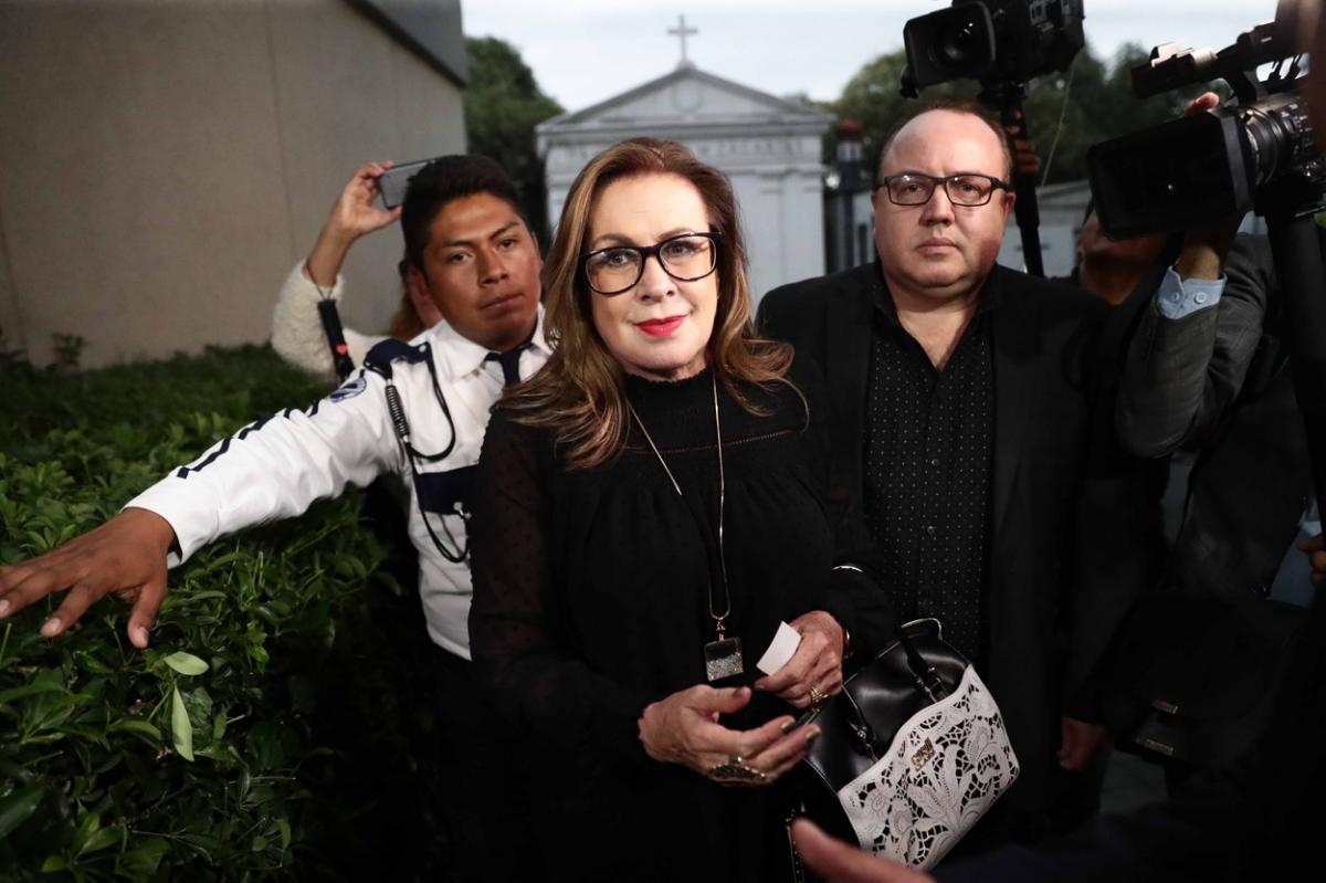 Laura Zapata poartă haine negre și are ochelari de vedere, dar și părul desprins