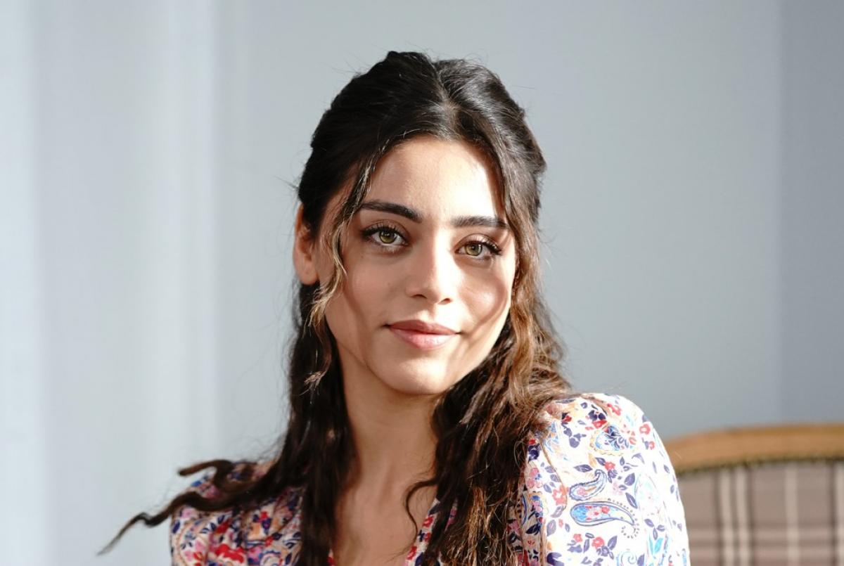 Sıla Türkoğlu poartă o rochie cu flori și are părul desprins