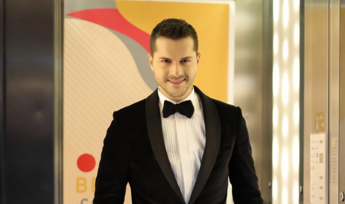 Alperen Duymaz poartă o cămașă albă și un sacou negru cu papion