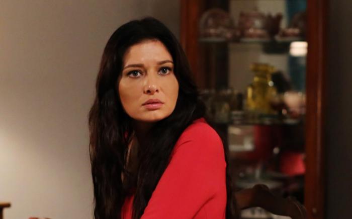Nurgül Yeşilçay poartă o bluză roșie cu mâneci lungi și are părul desprins