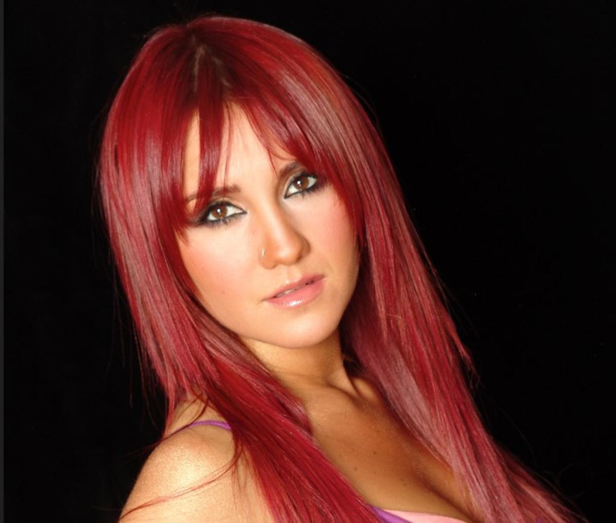 Dulce María poartă părul roșcat, lung și desprins