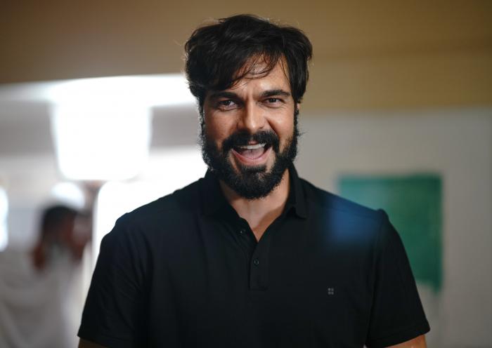 Halil İbrahim Ceyhan poartă o cămașă neagră și zâmbește