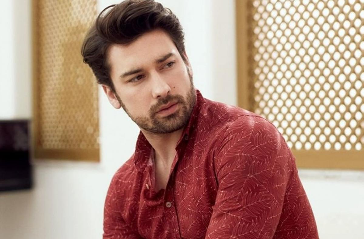 Alp Navruz poartă o cămașă vișiniei