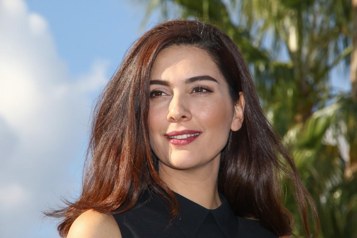 Bergüzar Korel poartă o rochie neagră fără mâneci și are părul desprins