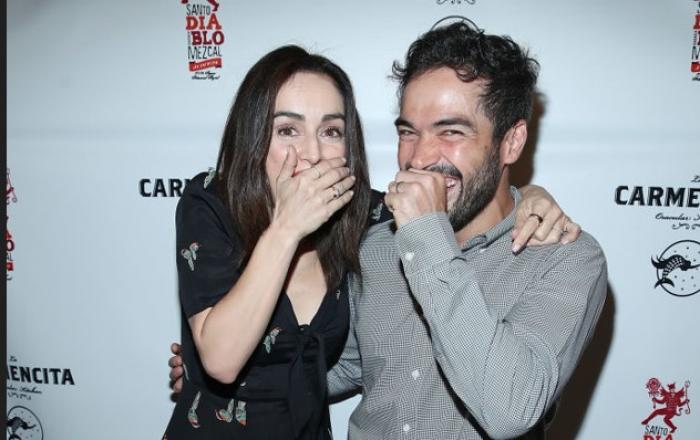 Alfonso Herrera poartă o cămașă cu mânecă lungă, iar Ana de la Reguera poartă o rochie neagră cu decolteu