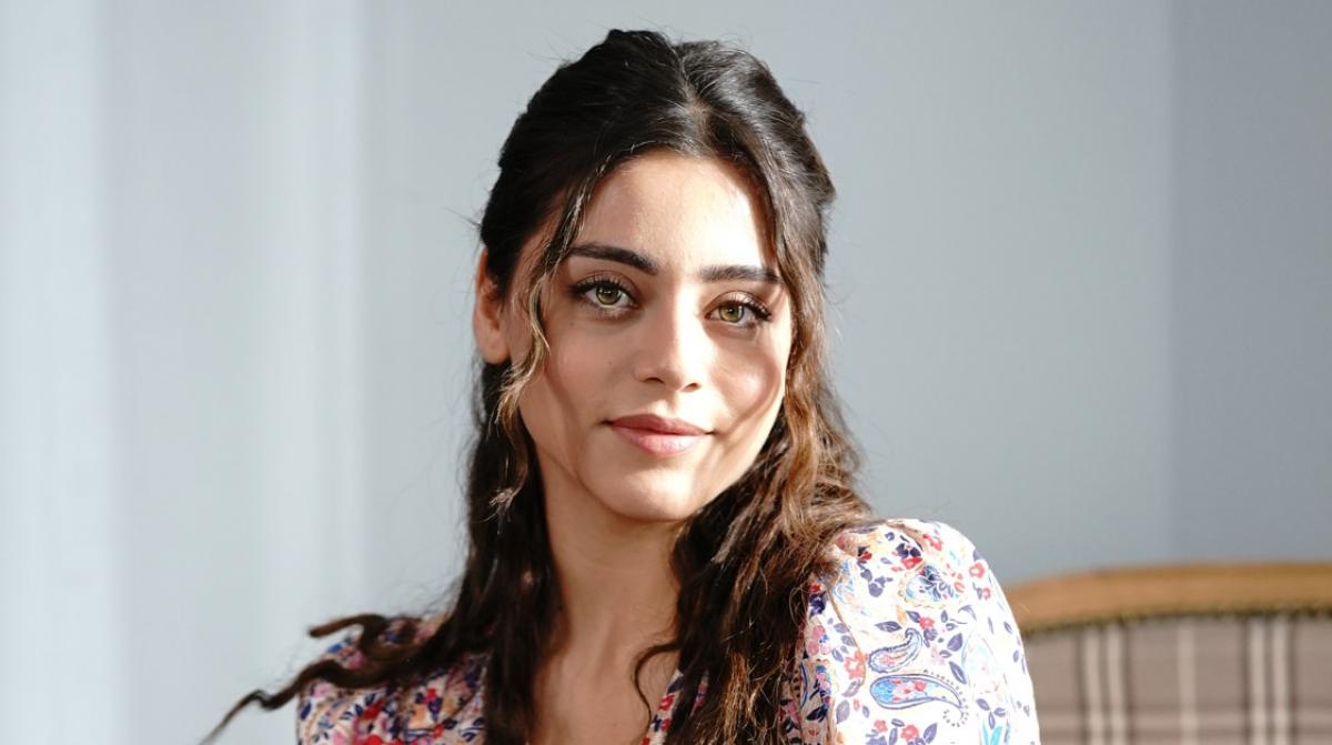 Sıla Türkoğlu poartă o rochie cu flori și are părul coafat simplu