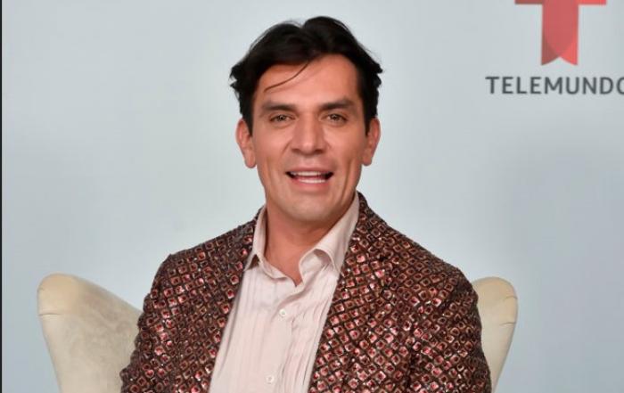 Jorge Salinas poartă o cămașă deschisă la culoare și un costum cu imprimeu