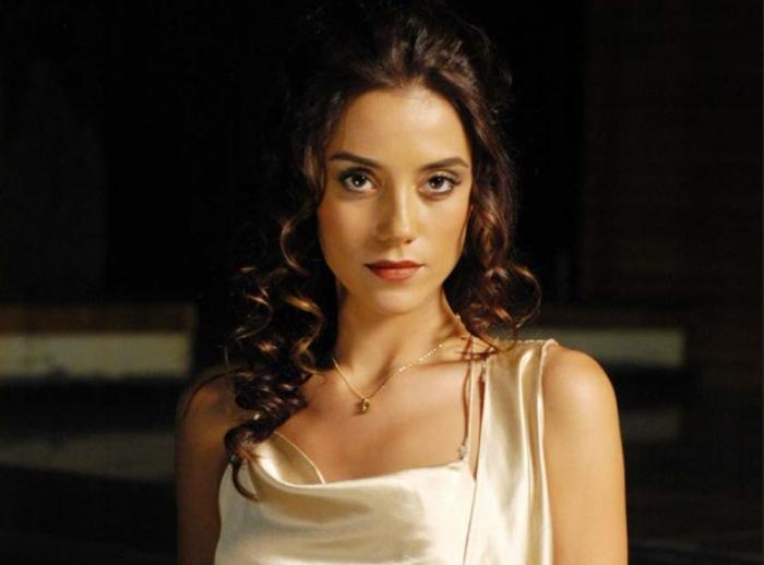 Cansu Dere poartă o rochie de mătase și are părul desprins, ondulat