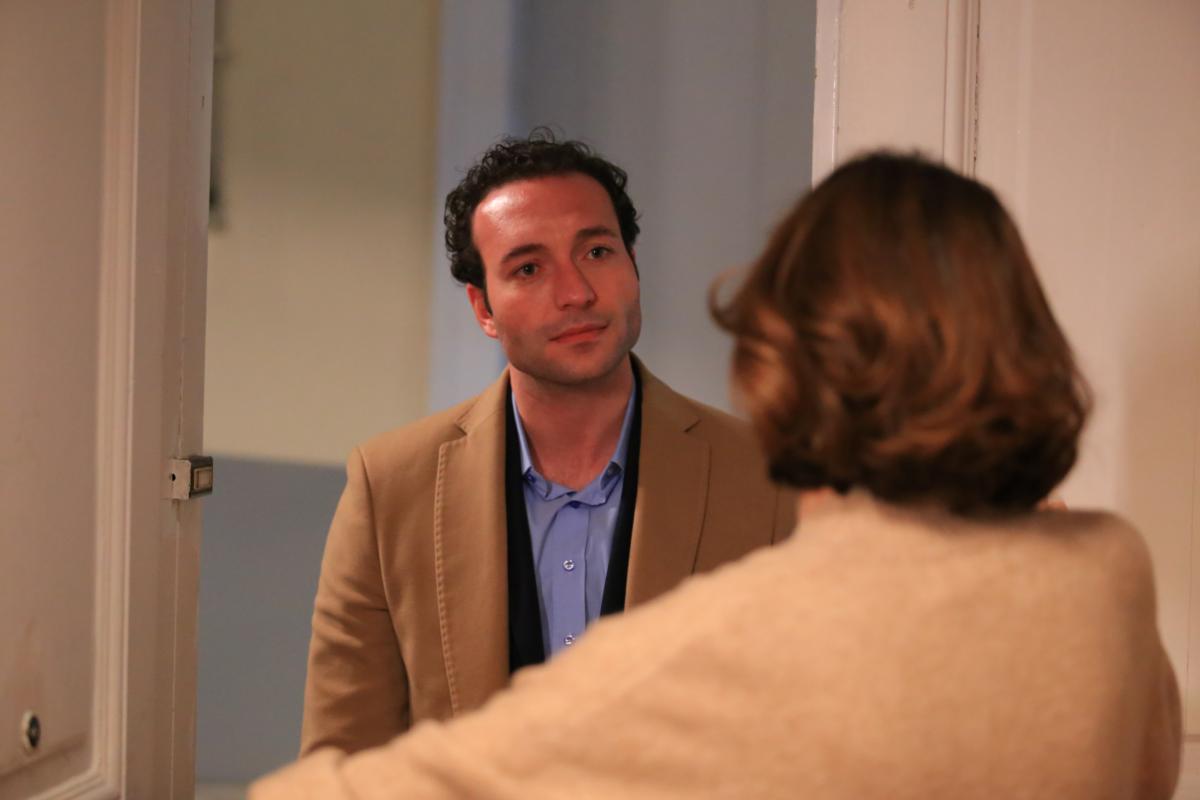 Gorkem Sevindik poartă o cămașă albastră și un palton maro