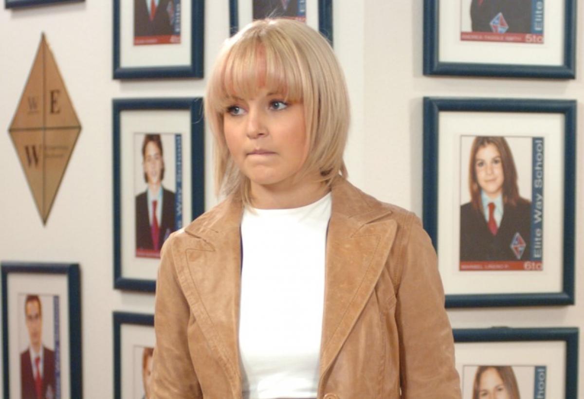 Angelique Boyer poartă un top alb ce îi lasă la vedere abdomenul și o bluză maro pe deasupra