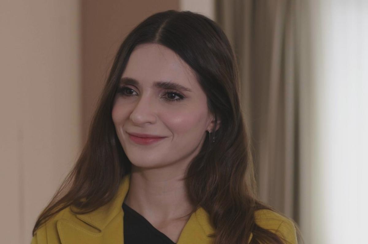 Meriç Aral poartă părul lung desprins și zâmbește