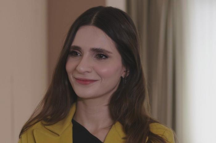 Meriç Aral poartă părul lung desprins și zâmbește