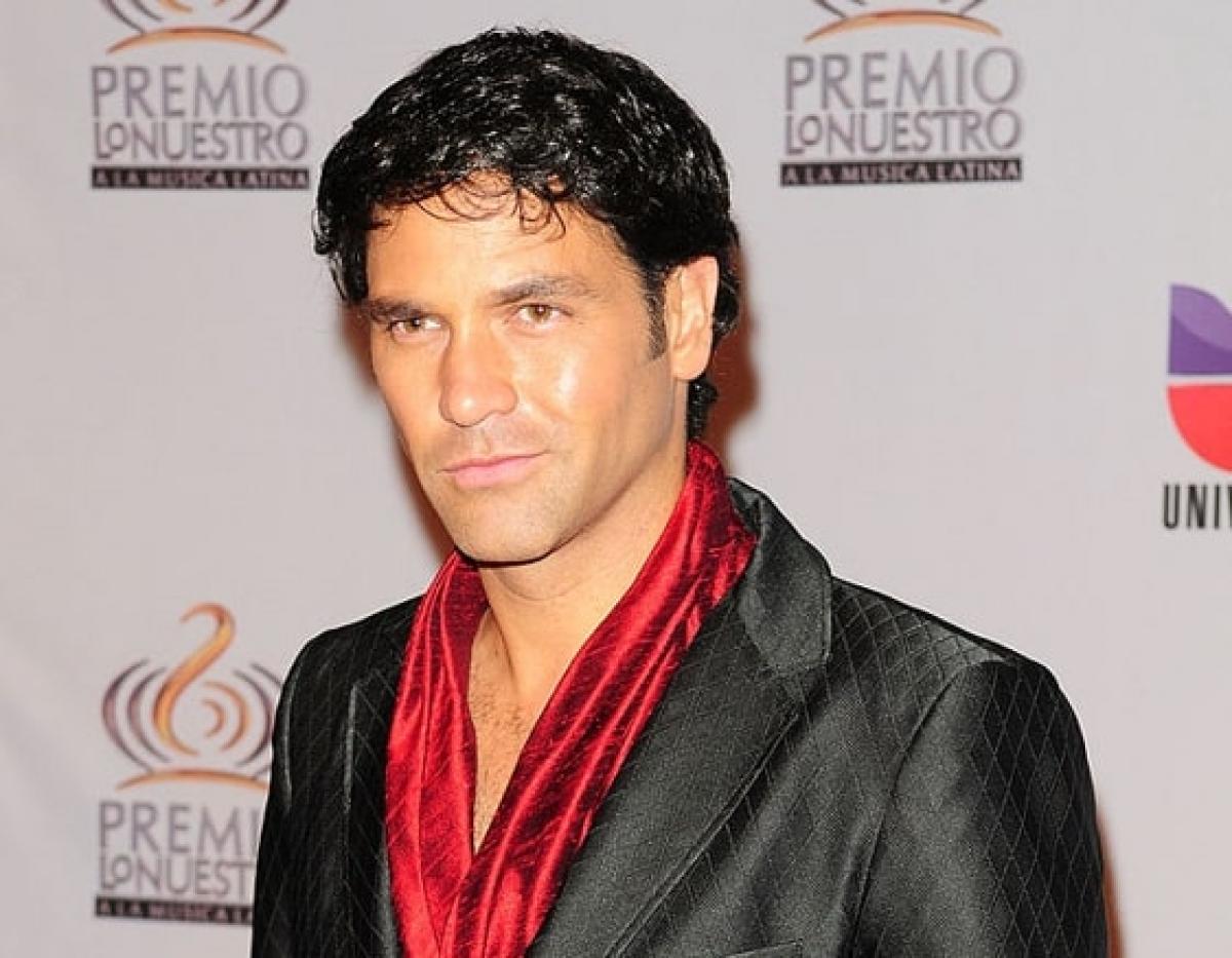 Valentino Lanús poartă un sacou negru și o cămașă roșie