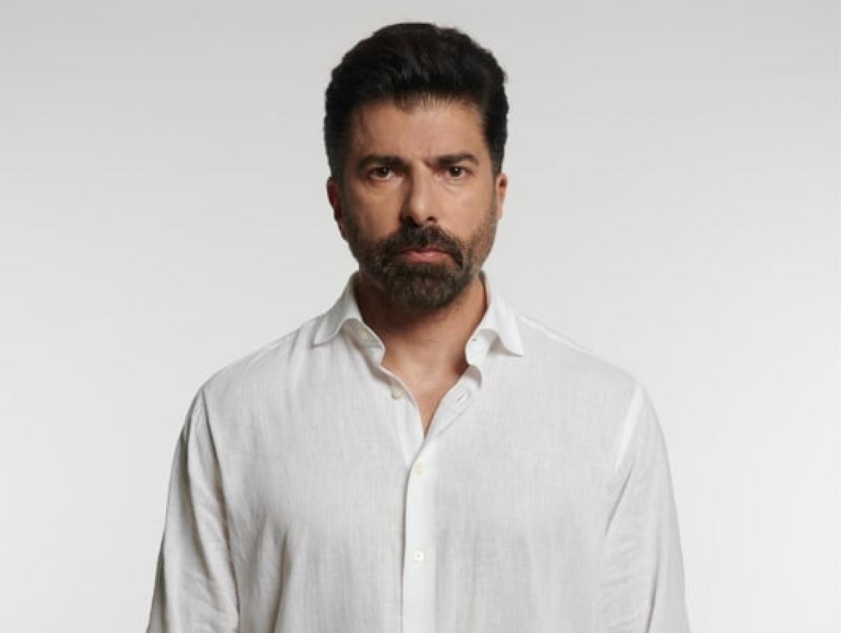 Cenk Torun poartă o cămașă albă cu mâneci lungi