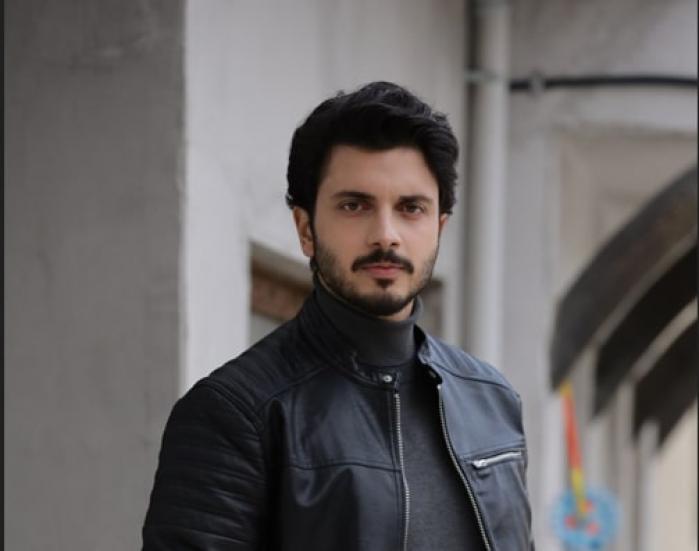 Ali Yağız Durmuş poartă o geacă neagră de blugi