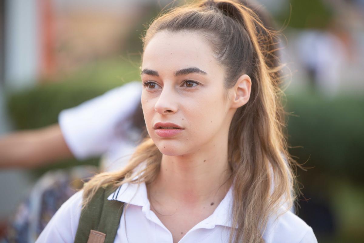 Hira Koyuncuoglu poartă un tricou alb și părul desprins