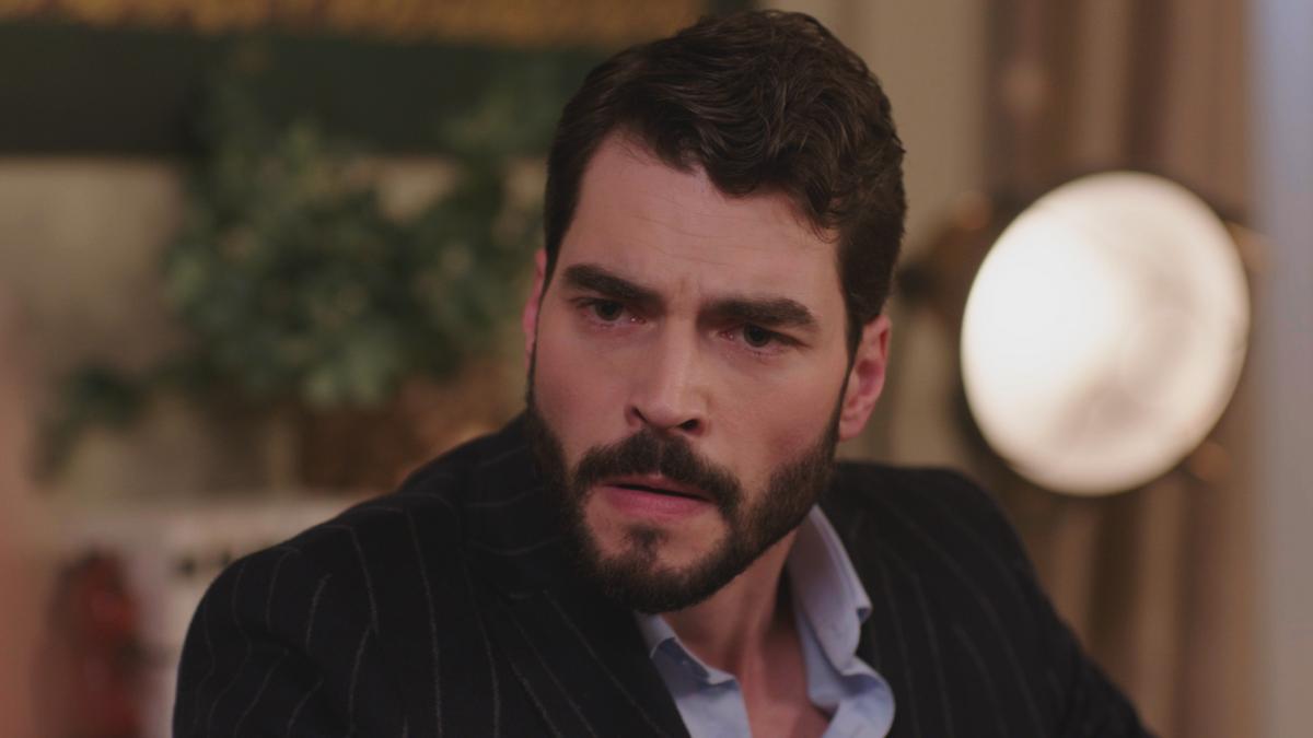 Akın Akınözü poartă o cămașă albastră și sacou negru