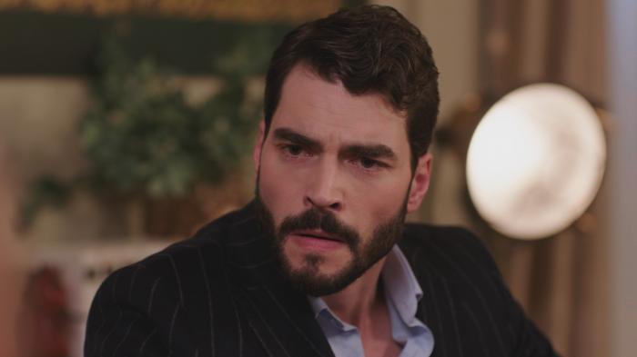 Akın Akınözü poartă o cămașă albastră și sacou negru