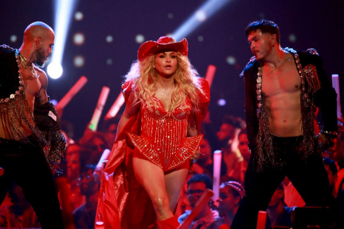 Paulina Rubio poartă un costum roșu și este pe scenă