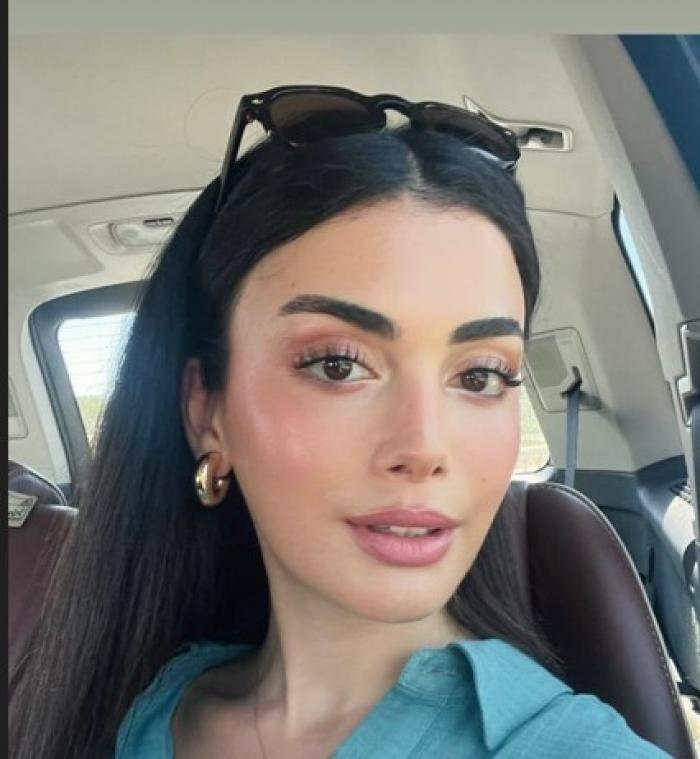 Özge Yağız poartă părul desprins și are o pereche de ochelari pe cap