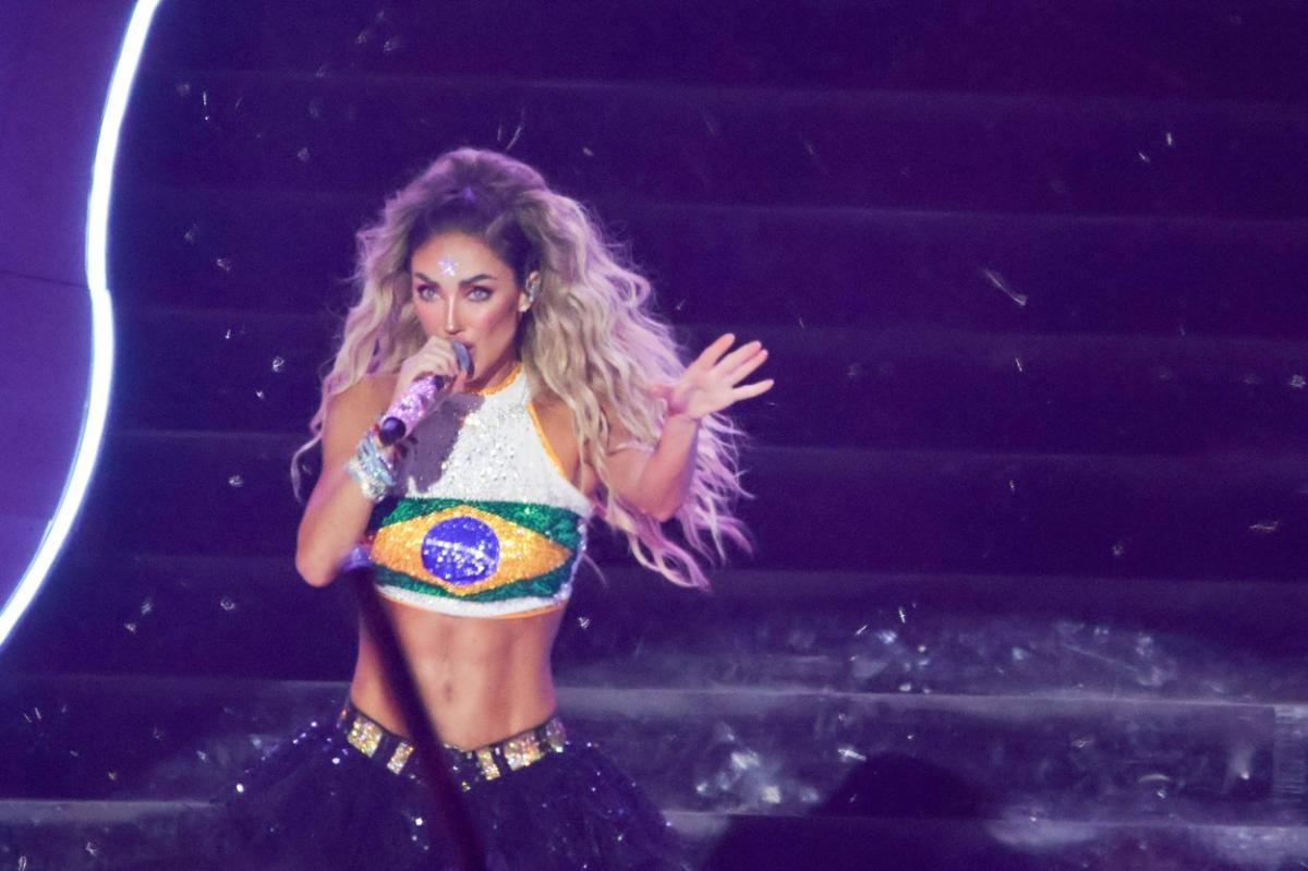 Anahi poartă un top scurt alb cu steagul Braziliei și părul desprins