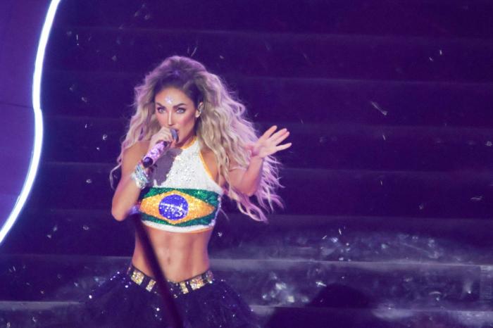 Anahi poartă un top scurt alb cu steagul Braziliei și părul desprins