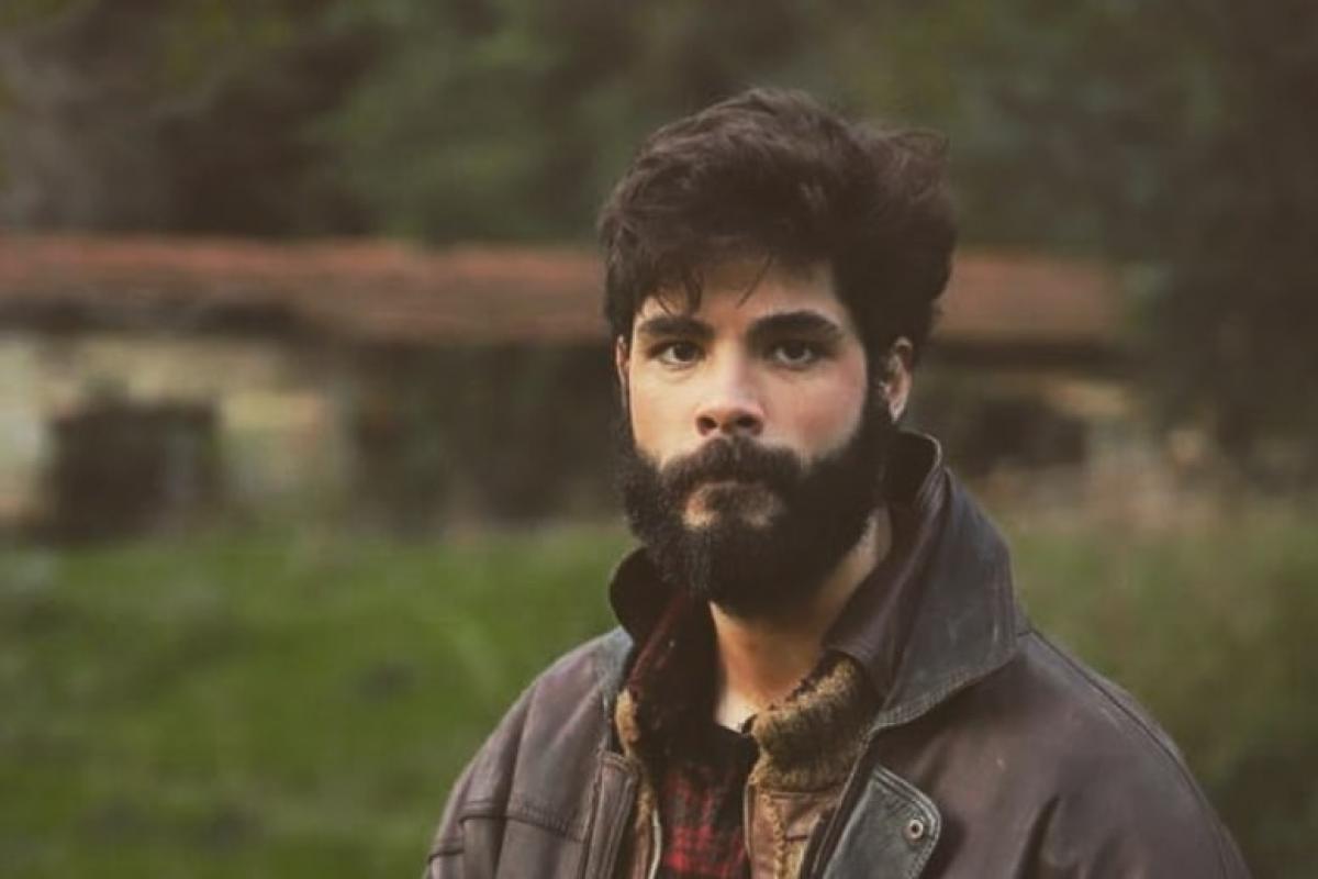 Genco Özak poartă o jachetă închisă la culoare