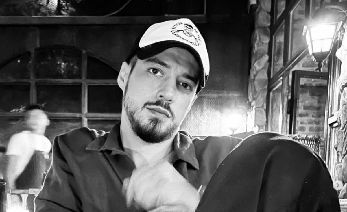 actor poartă o șapcă și cămașă