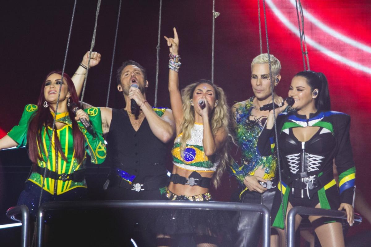 artiști pe scenă stau unul lângă celălalt și dansează