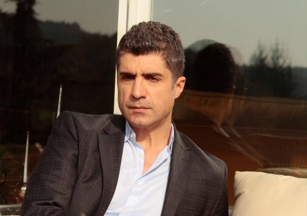 actor poartă o cămașă albă și sacou negru