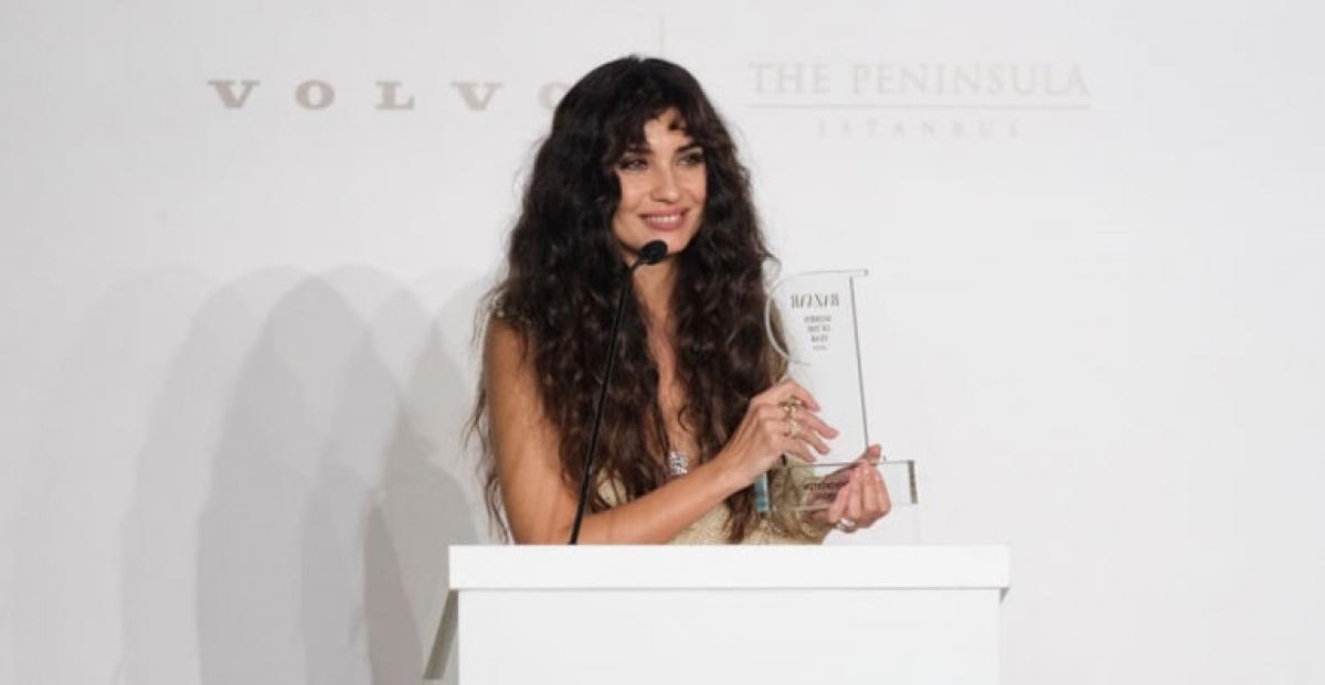 actrița poartă părul lung, desprins și ține în mână un premiu