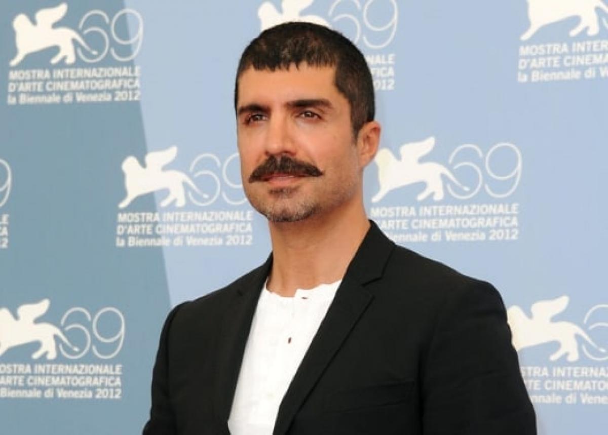 actor poartă un tricou alb și sacou negru