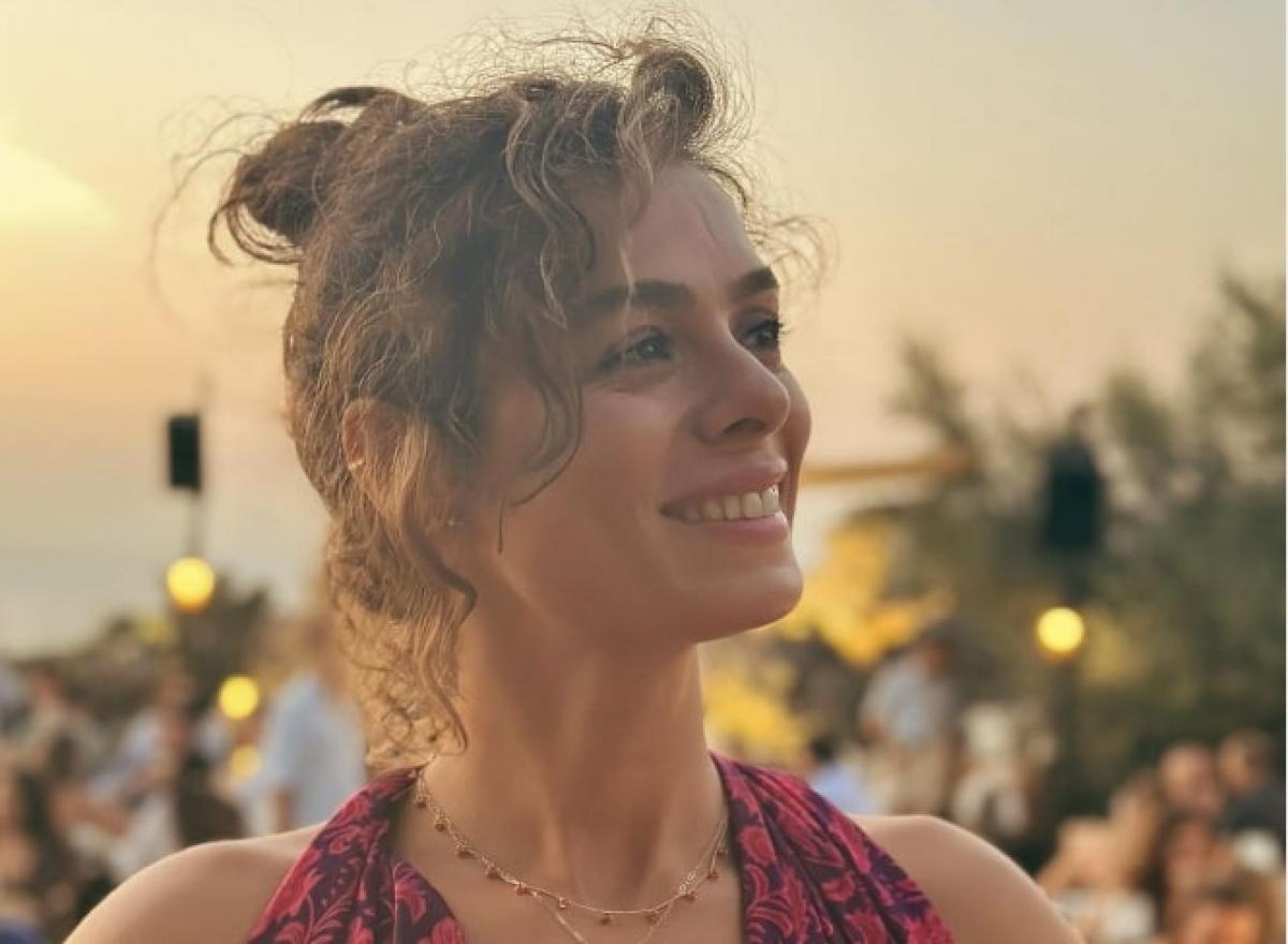 Özge Özpirinçci poartă părul prins în coc și zâmbește