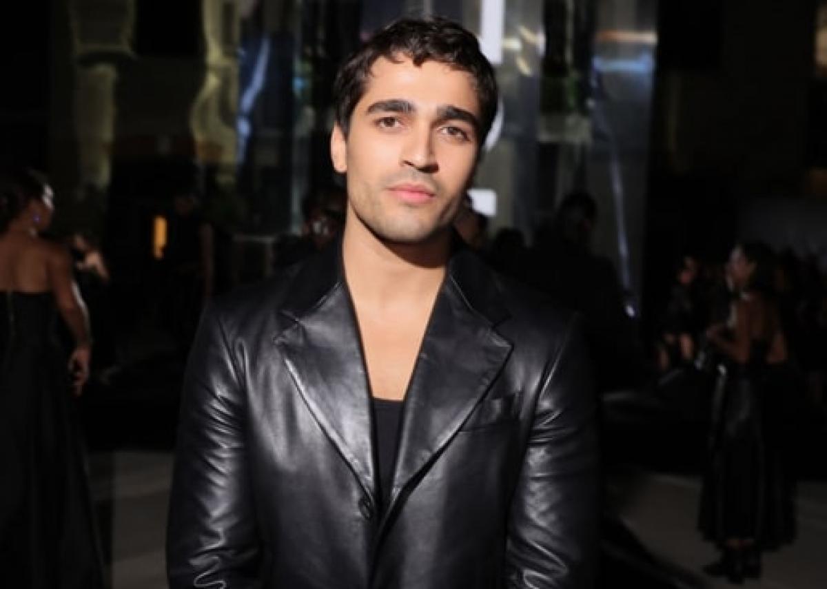 actor poartă un tricou negru și o geacă neagră de blugi