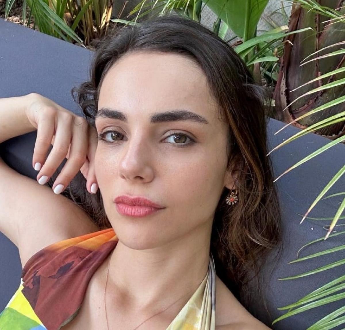 actrita poarta parul desprins și ține mâna dreaptă la ureche