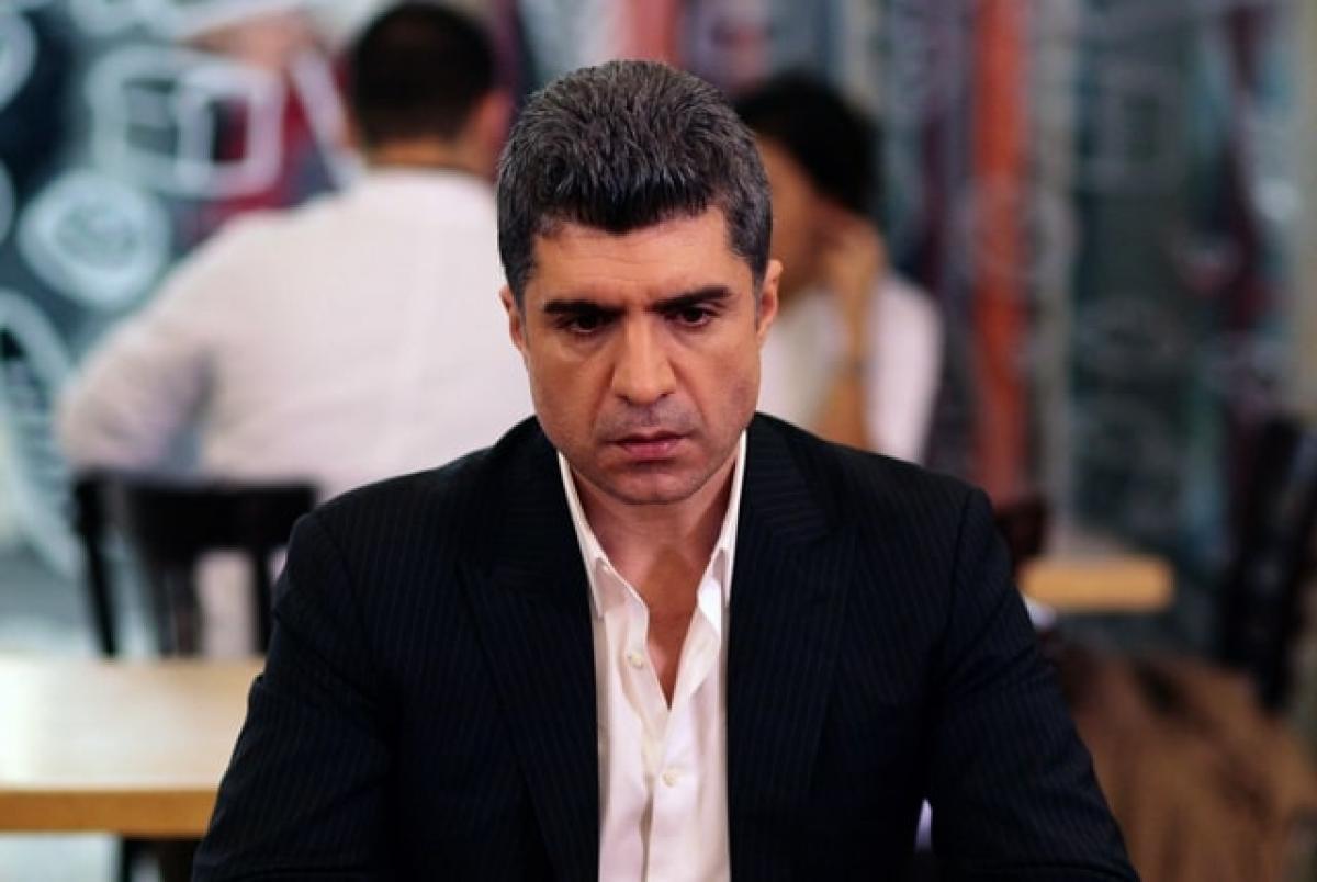 actor poartă cămașă albă și sacou negru