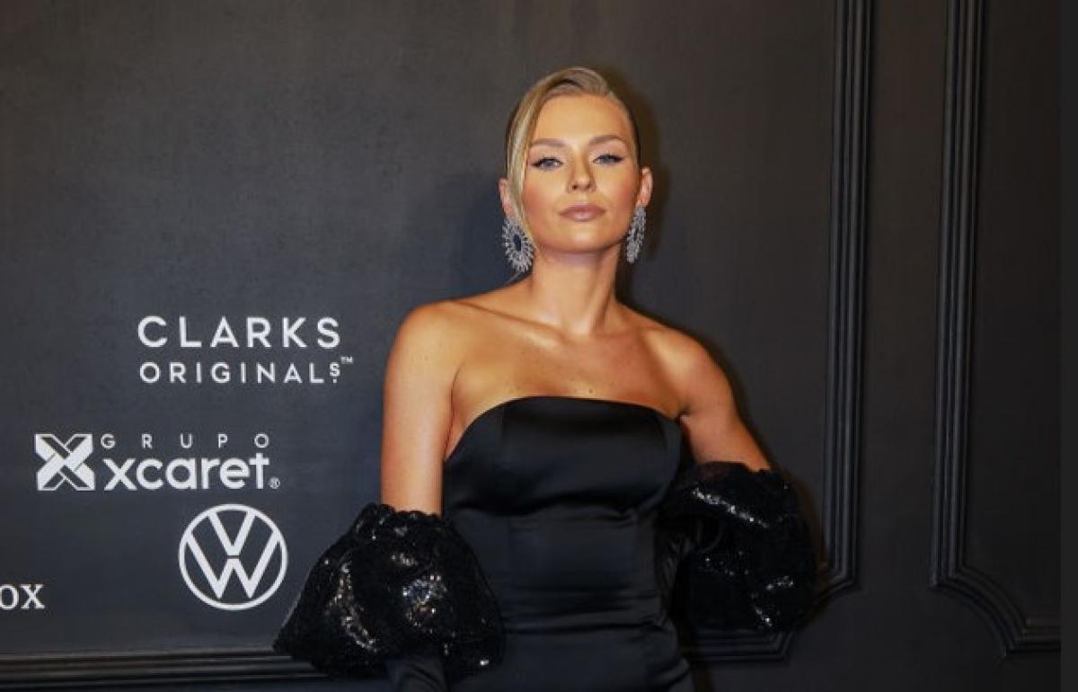 Irina Baeva poartă o rochie neagră fără mâneci și mănuși de aceeași culoare
