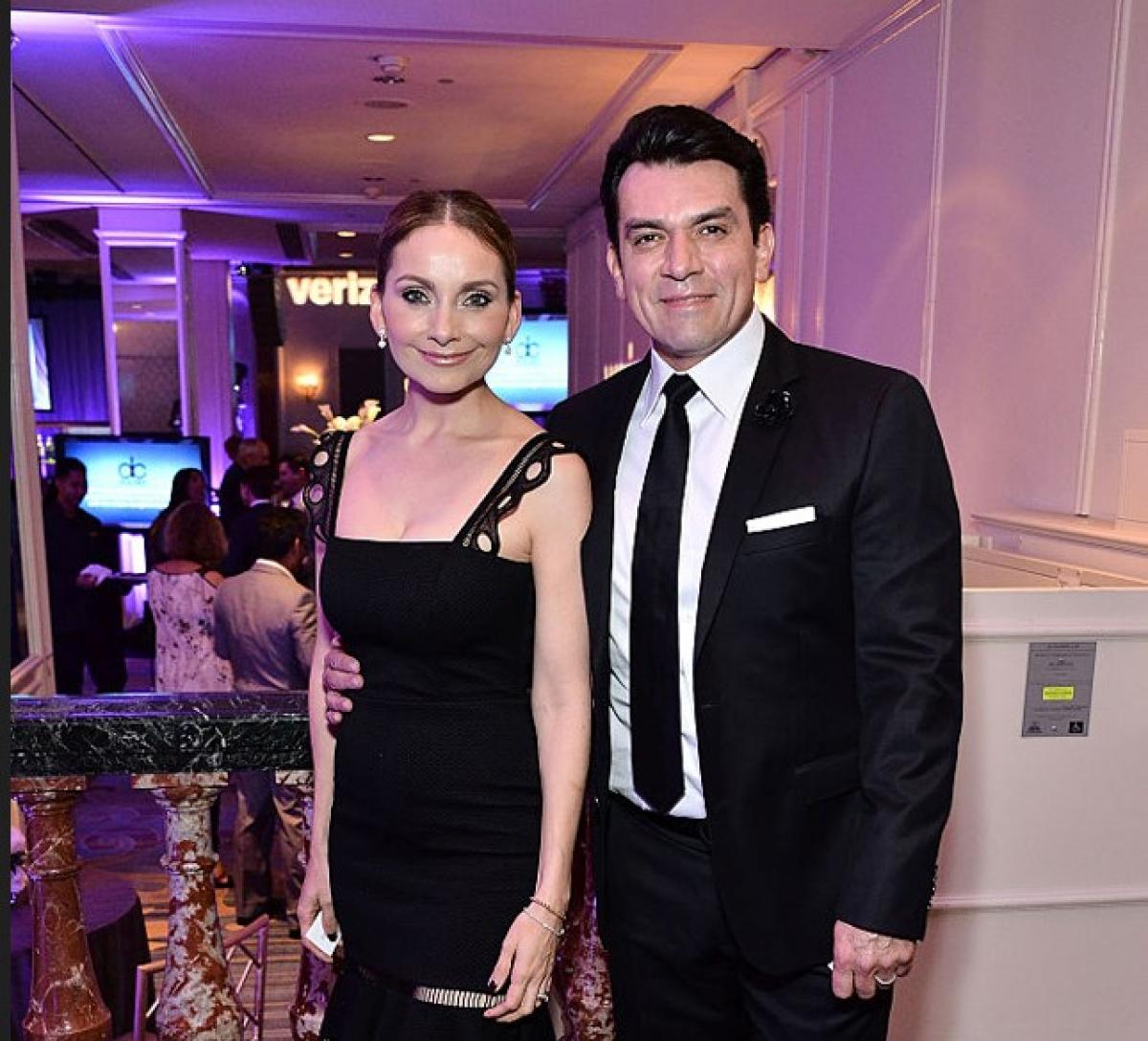 Elizabeth Álvarez poartă o rochie neagră cu decolteu și stă lângă Jorge Salinas