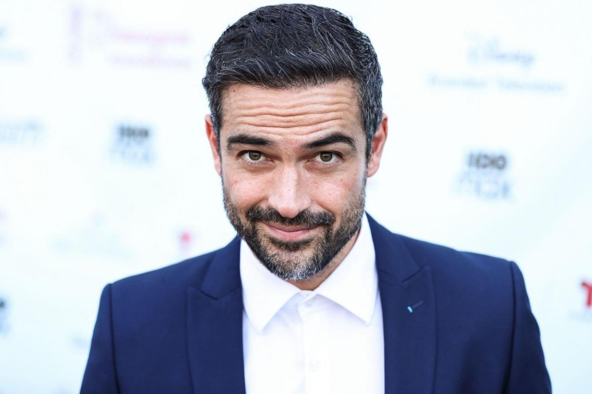 Alfonso Herrera poartă o cămașă albă și un sacou albastru închis