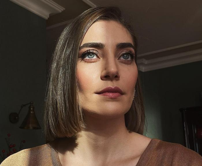 Öznur Serçeler poartă părul scurt, desprins și este machiată