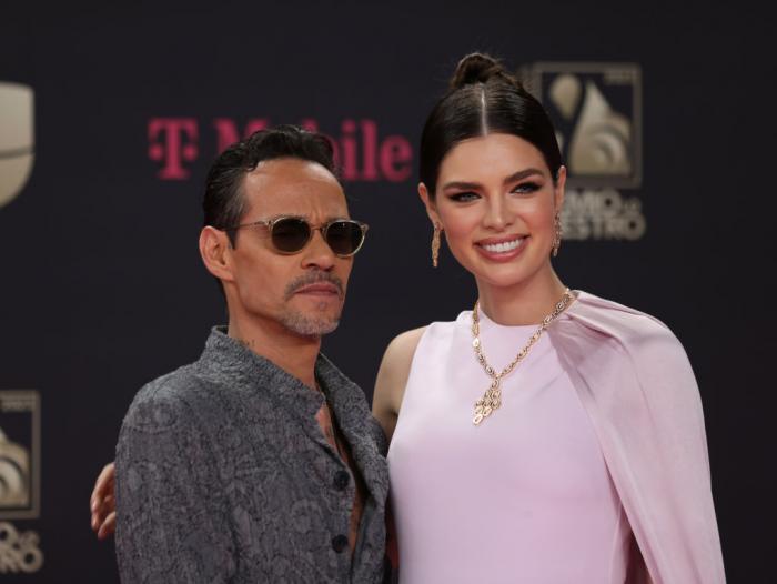 Marc Anthony poartă un costum, ochelari de soare și stă lângă Nadia Ferreira