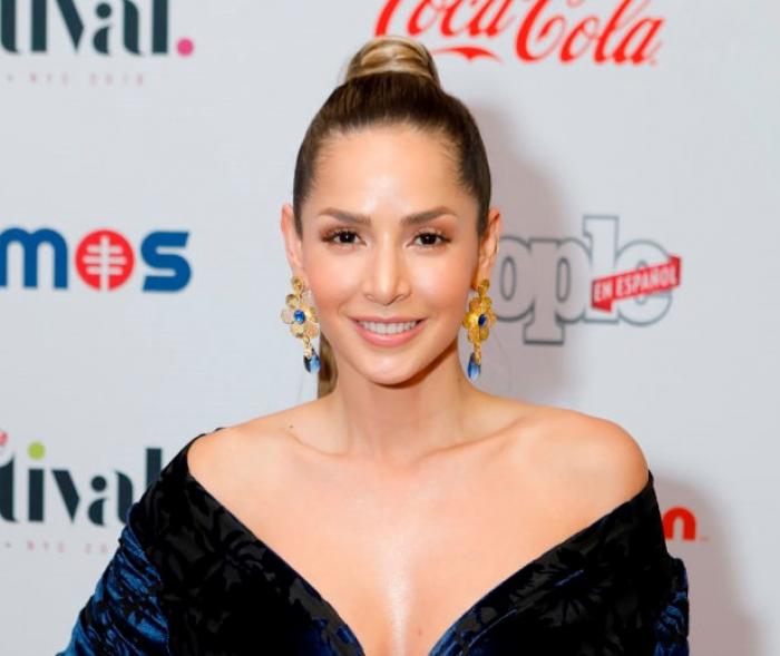 Carmen Villalobos poartă o rochie neagră cu decolteu și zâmbește