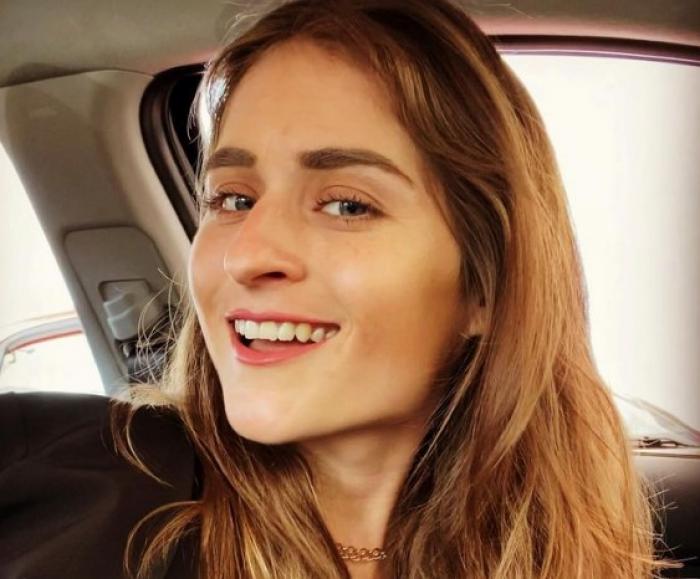 María Solares poartă părul lung și zâmbește