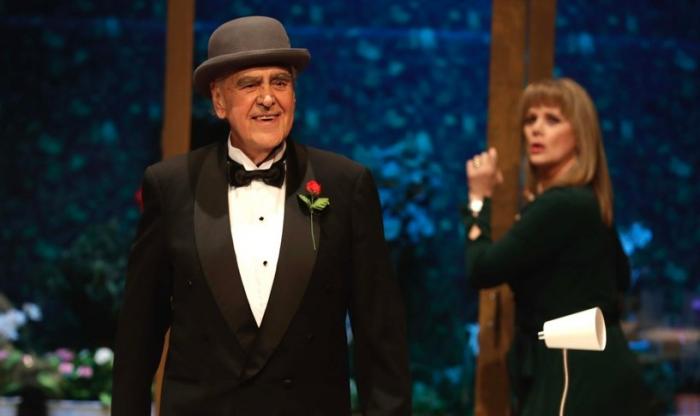 Eric del Castillo poartă un costum negru și o cămașă albă