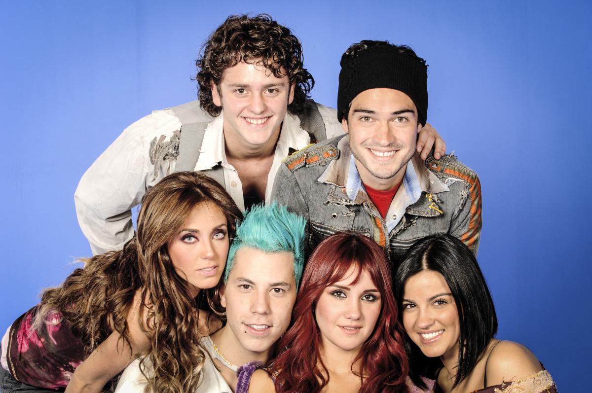 membrii formației RBD stau unul lângă celălalt și zâmbesc în fața camerei