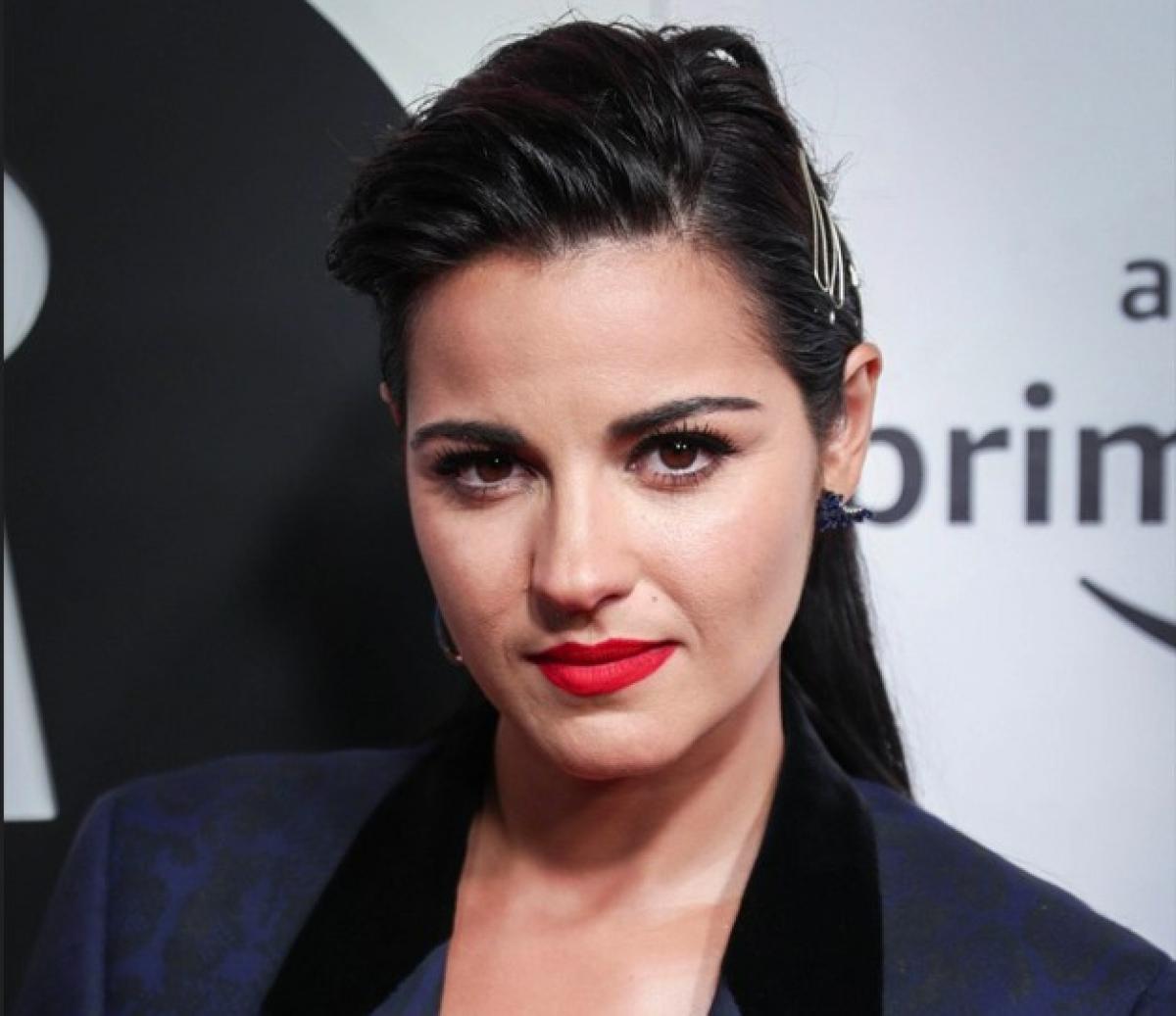 Maite Perroni poartă un sacou negru și are ruj roșu