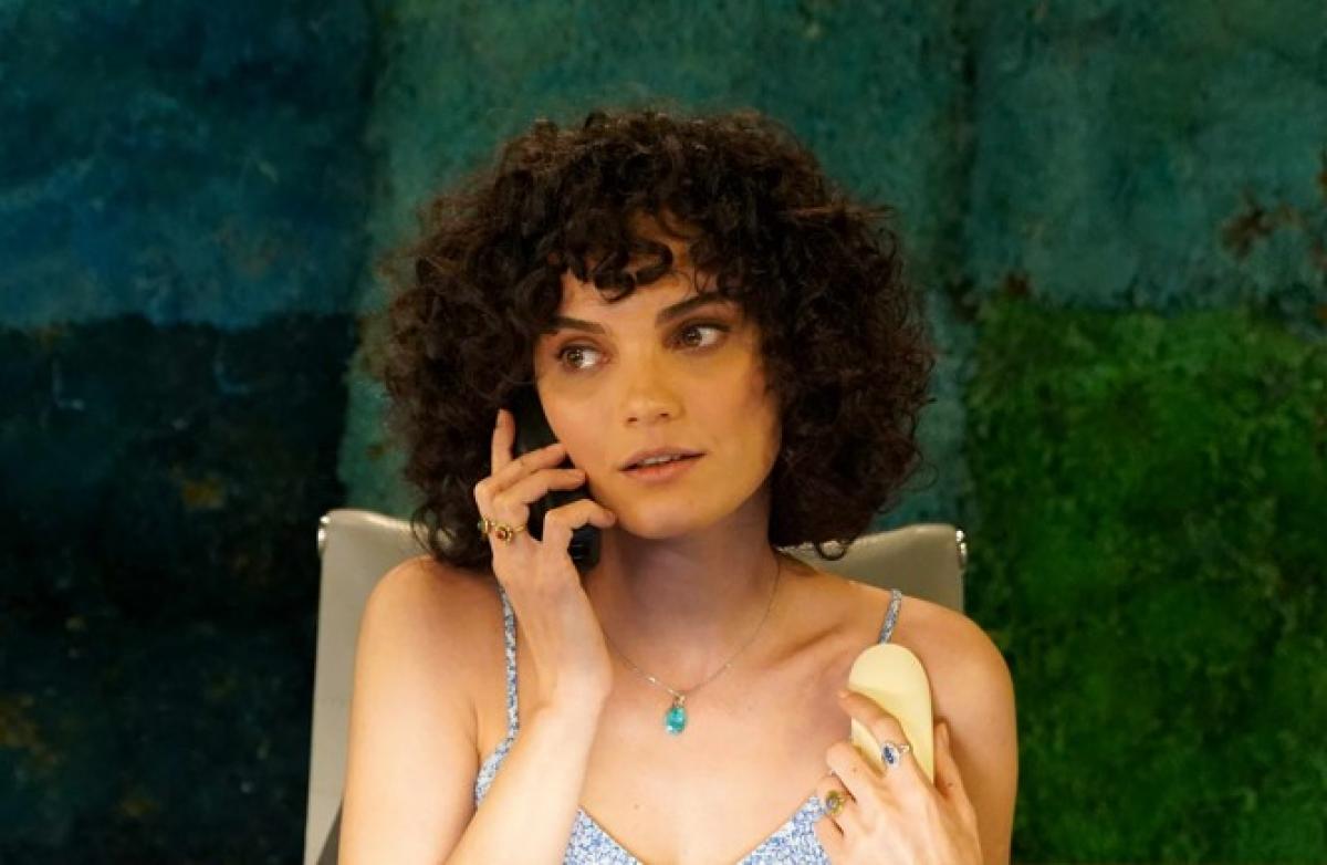 Nazlı Senem Ünal are părul scurt, creț și ține telefonul la urechea dreaptă